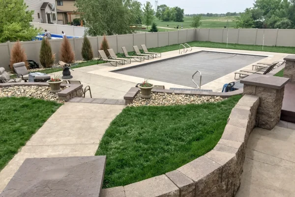 Backyard with decorative retaining wall and stamped concrete – Concrete Construction