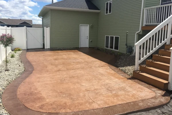 Backyard stamped concrete patio against house – Concrete Construction