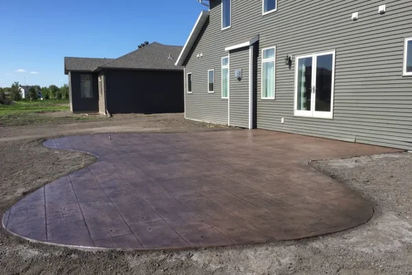 Curvy stamped concrete patio in backyard – Concrete Construction